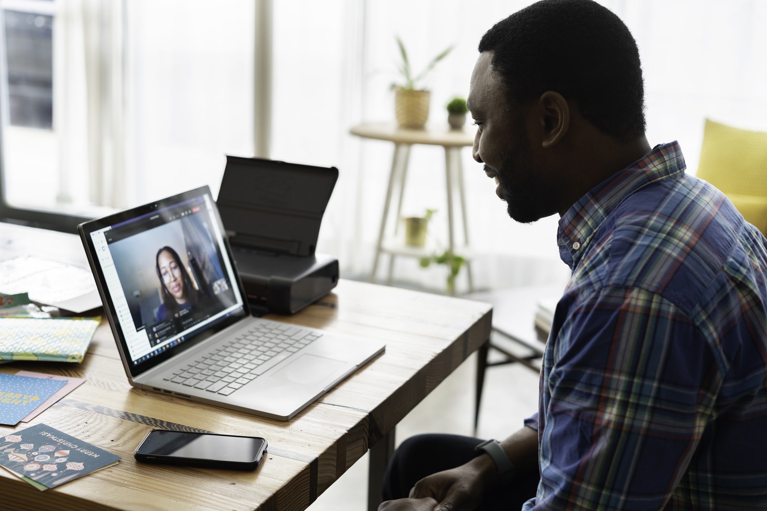 Stock image of a man using his laptop to speak to a woman on a video call.
